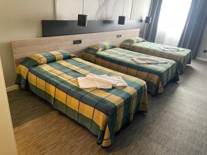 欧特瑞奥德瑞Area 507的酒店客房,配有三张床和毛巾
