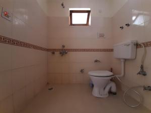 列城Rabyang Guest House and Homestay的一间带白色卫生间的浴室和窗户。