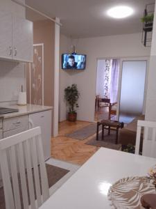 鲁马Apartman Breza的厨房以及带墙上电视的客厅。