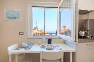 马斯诺维斯康蒂COME A CASA 19 - Romantic Studio的厨房配有白色的桌子和窗户。