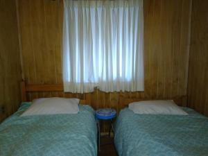 比亚里卡Cabaña entre Arboles的小型客房 - 带2张床和窗户