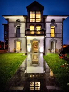 Villanueva de ArdisanaVilla Marta Casa de Indianos Passive House的一座白色的大房子,灯火通明