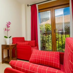 巴约讷Hotel Arce的客厅设有2张红色的沙发和1扇窗户