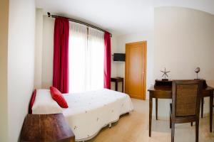 巴约讷Hotel Arce的一间卧室配有一张床、一张书桌和一个窗户。