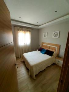 格拉纳达Casa de campo Padul的一间卧室设有一张大床和一个窗户。