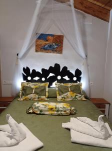 Olocau del ReyApartamentos CASA RURAL EL VENTANICO的一间卧室配有一张带绿床单和枕头的床。