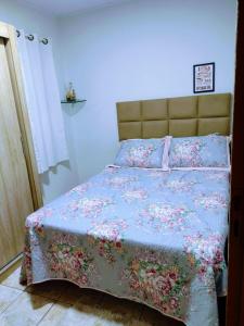 巴纳内拉斯Casa aconchegante ao lado da Igreja Matriz- Bananeiras-PB的一间卧室配有一张带花卉床罩的床