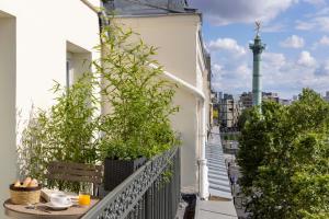 巴黎Le Petit Beaumarchais Hotel & Spa的大楼内的阳台,配有桌子和植物