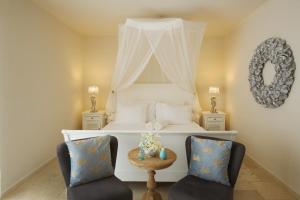 克拉伦代克Ocean Breeze Boutique Hotel & Marina的卧室配有白色的床和两把椅子