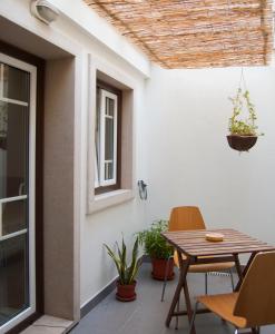 塞辛布拉Casa da Tia Matilde的庭院配有木桌和椅子