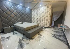 拉合尔Burj Al Bahria Town Luxury Suites的一间卧室设有一张床和一面墙