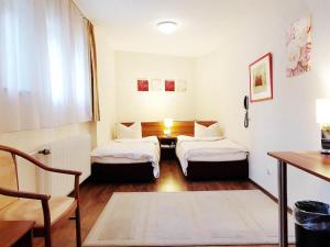 巴特索登-萨尔明斯特Gartenhotel LandArt的小房间设有两张床和一张桌子