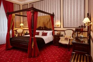 杜塞尔多夫Hotel Villa Achenbach的一间卧室配有一张天蓬床和两把椅子