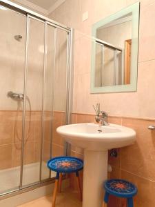 里瓦德奥FANTASTICO APARTAMENTO EN RIBADEO的一间带水槽和两个凳子的浴室