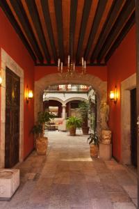 莫雷利亚莫雷利亚米西安教堂酒店的一座拥有红色墙壁和盆栽植物的建筑的入口