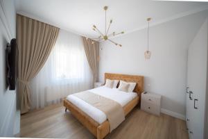 奥拉迪亚BlueSky Ultra-Central Premium Apartment的白色卧室配有一张床和一个吊灯