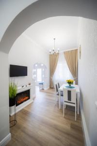 奥拉迪亚BlueSky Ultra-Central Premium Apartment的白色的客厅配有桌子和壁炉