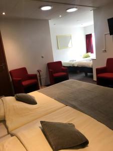 奥尔登扎尔赫特兰德胡伊斯酒店的酒店客房,设有两张床和红色椅子