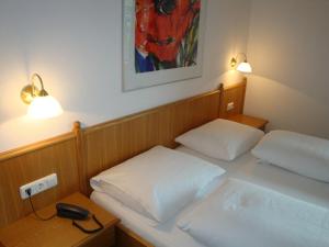 韦斯滕多夫奥地利加尼酒店的配有两张床铺、两盏灯和一部电话的客房