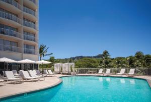 檀香山威基基海岸公园酒店的一个带躺椅的游泳池和一间酒店