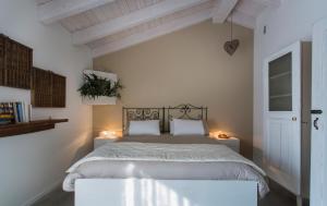 维洛尔巴A Casa Di Ita的白色卧室配有一张带两个枕头的大床