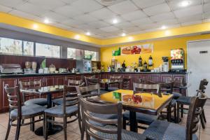 萨拉索塔Quality Inn Sarasota North Near Lido Key Beach的一间带桌椅和柜台的餐厅