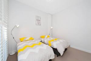 安娜湾Ocean Views 41的一间卧室配有两张带黄白色枕头的床