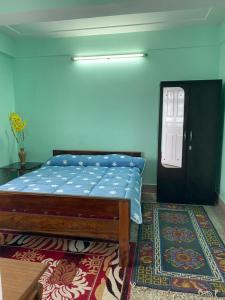 大吉岭B&B Homestay的一间卧室配有一张床,一扇门铺有地毯