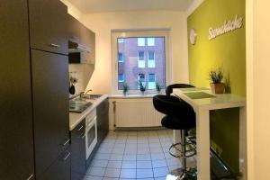 汉诺威Trade fair and business apartment - Hannover Messe的厨房配有水槽、冰箱和窗户。