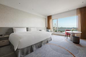 苏州苏州洲际酒店的一张大白色的床,位于一个设有大窗户的房间