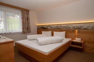 卡普尔Zappartements的一间卧室配有一张大木床和白色床单