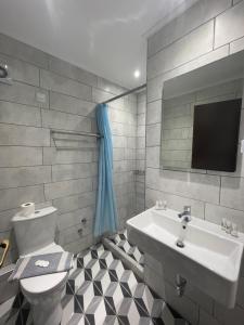 萨索斯Mironi & Victoria Hotel的一间带水槽和卫生间的浴室以及一台电视。