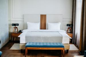 伊尔库茨克Hotel Amurskiy的一间卧室配有一张大床和蓝色长凳