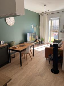 塞特港Appartement cosy plein centre de Sète的一间带木桌的客厅和一间餐厅