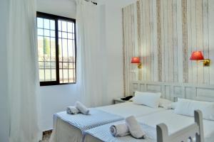 科尔多瓦玛丽莎酒店的白色客房的两张床,设有窗户