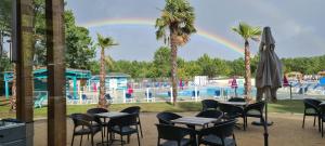 波讷地区圣朱利安Mobilhome 2 ch,1 salon 40m2 de Charme dans camping ***的一个带桌椅的游泳池的彩虹