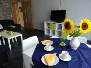 米歇尔施塔特Annettes Ferienwohnung的客厅配有带向日葵的桌子