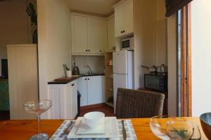 雅可布湾Hallo Jacobsbaai的小厨房配有木桌和木桌,铺有四柱木头。