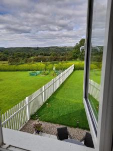 多尼戈尔Doonan Breeze的从带白色围栏的庭院窗户欣赏美景