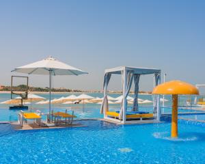 迪拜C Central Hotel and Resort The Palm的一个带椅子和遮阳伞的游泳池