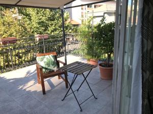 佩罗Appartamento con terrazza e posto auto Libri e Giardini的一把椅子坐在带雨伞的庭院