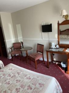 纳斯茅那汉海港酒店的酒店客房带一张床、一张桌子和椅子