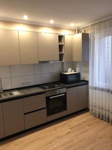 伊兹梅尔Квартира студия的厨房配有白色橱柜和炉灶烤箱。