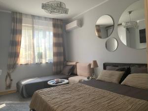 贝尔格莱德Apartment Skadarlija的一间卧室配有一张床、一张沙发和一面镜子
