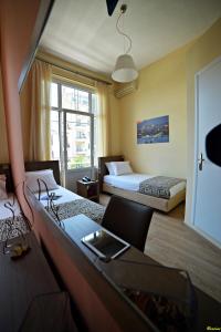 塞萨洛尼基奥勒斯塔斯卡斯托利亚酒店的酒店客房,设有两张床和一张沙发