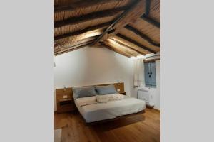 托尔托利Casetta da scoprire a due passi dal centro的一间卧室设有床铺、木地板和外露天花板