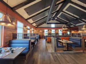 FlorencevilleAmsterdam Inn & Suites Florenceville的一间设有蓝色桌椅的餐厅,以及砖墙