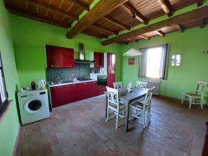 CampitelloCorte Ventaglio的厨房设有绿色的墙壁和桌椅