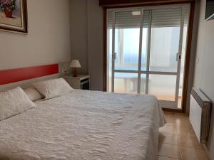 坎加斯德穆拉索普拉亚酒店的卧室设有白色的床和大窗户