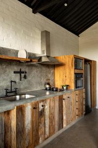 贡萨尔维斯Mataka'a - Chalé Industrial na Mantiqueira的一个带木制橱柜和水槽的厨房